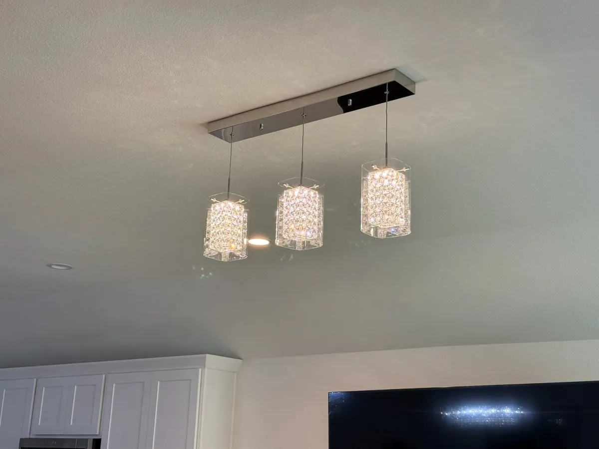 Three crystal pendant lights installed from a rectangular ceiling canopy