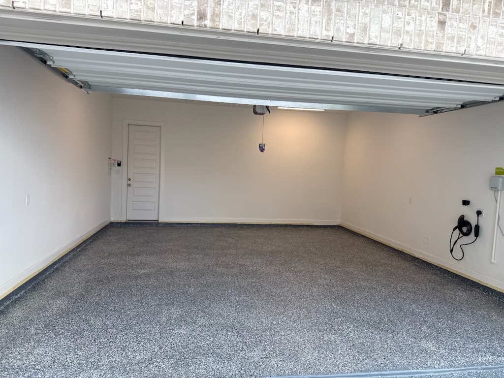 Finished gray flake garage floor coating inside an open residential garage